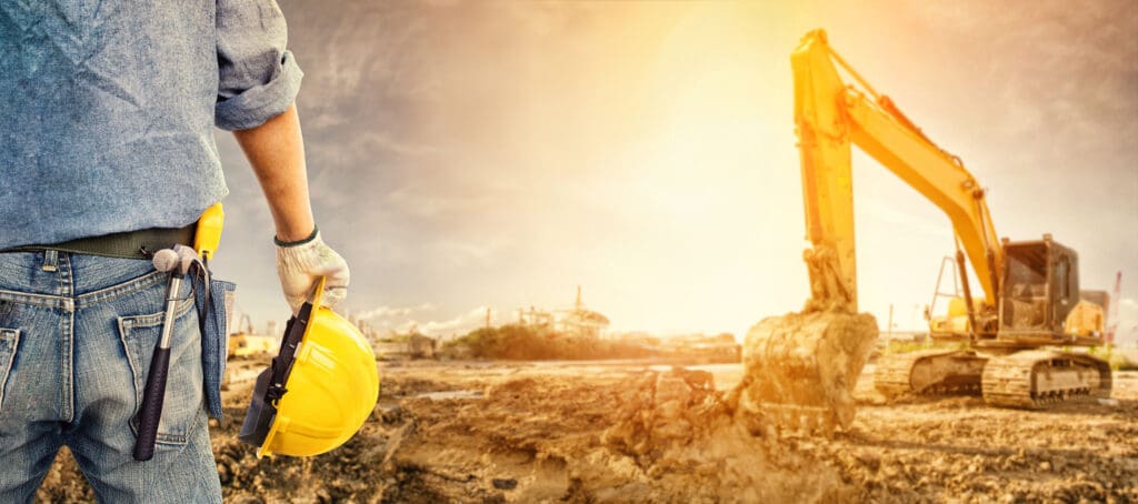 Construction worker near excavator on sunny day
